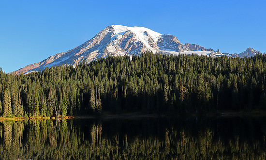 Mount Rainier National Park is ocated about 85 miles southeast of Seattle;	magnificent vistas and lakes, camping and hiking. This stratovolcano reaches a summit peak of 14,411 feet above sea level, and is the highest mountain in Washington and the Cascade Range. 