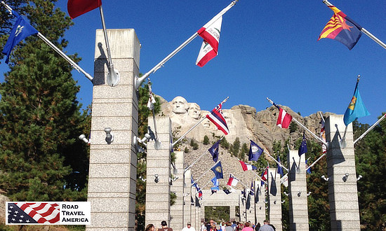 After purchasing tickets and parking, visitors walk through the Avenue of Flags as they approach the stone carvings at Mount Rushmore