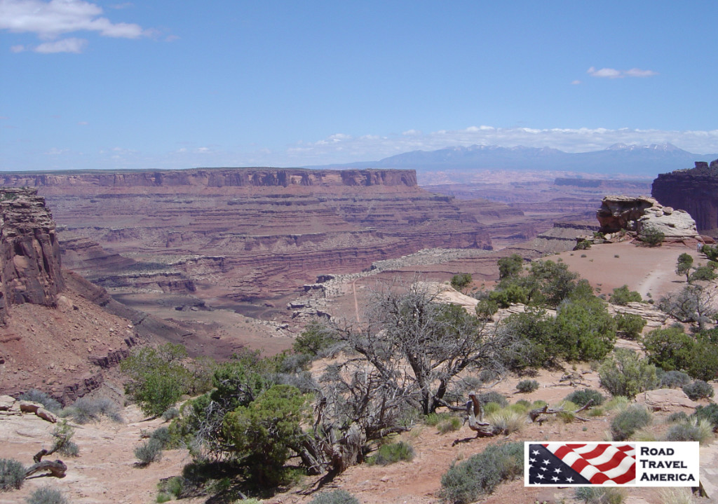 Rugged terrain at Canyonlands National Park, with a dirt road at the bottom of the canyon